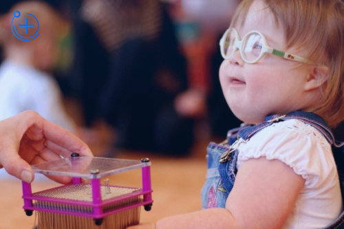 Девочке дают игрушку Девочке дают игрушку